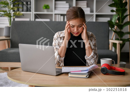 Stressed young Asian female college student preparing for the exam in her living room. 102251018