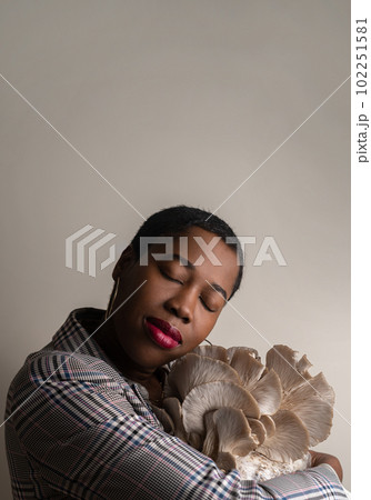 Beautiful african famele holding oyster mushrooms Beautiful african famele holding oyster mushrooms 102251581