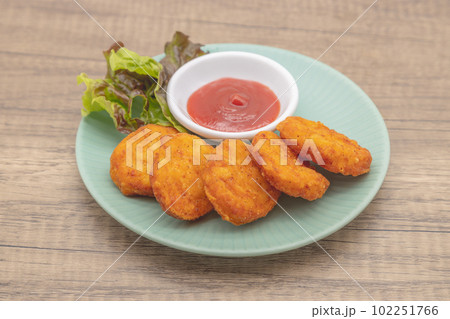 チキンナゲットとケチャップが青い皿に盛り付けられている チキンナゲットとケチャップが青い皿に盛り付けられている 102251766