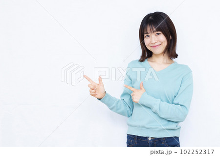 白い背景の前で人差し指を立てる30代の女性 102252317