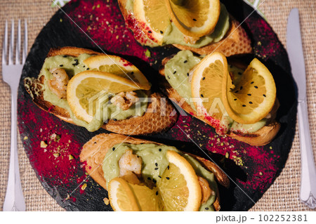 Top view of bruschetta with guacamole and shrimps. Delicious food in restaurant 102252381