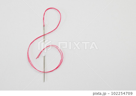 Red cord through the Needle In The Form Of A Treble Clef Red cord through the Needle In The Form Of A Treble Clef 102254709