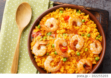 Yellow rice with shrimp with some addition of vegetables and spices close-up in a bowl. horizontal top view 102255203