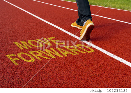 Man walk on the running track with a motivational quote written - MOVE FORWARD 102258185