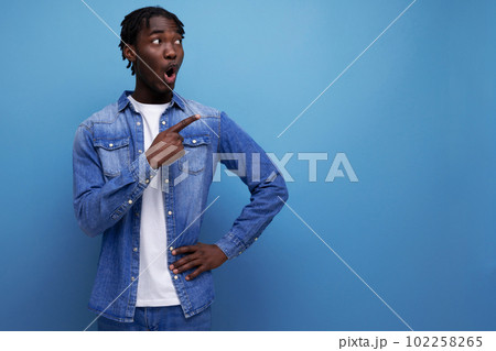 surprised stylish american young man with dreadlocks with a brilliant idea shows to the side 102258265