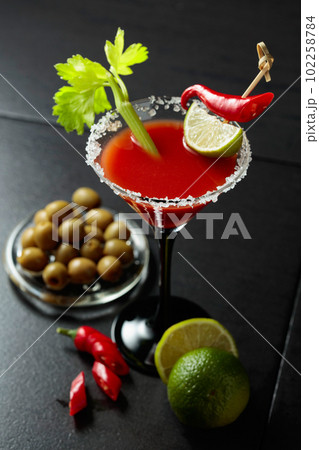 Bloody Mary cocktail with celery, lime, red pepper, and green olives. Bloody Mary cocktail with celery, lime, red pepper, and green olives. 102258784
