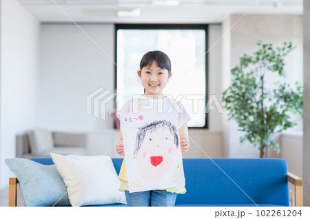 ママの似顔絵を見せる女の子 ママの似顔絵を見せる女の子 102261204