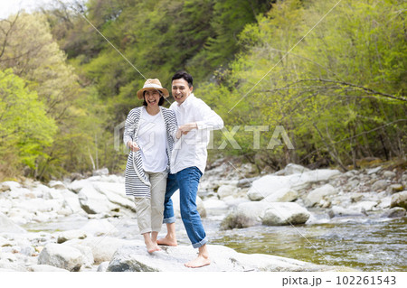 河原で水遊びを楽しむカップル 102261543
