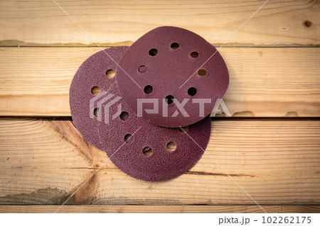 Round sandpaper discs for orbital sander. Wooden background Round sandpaper discs for orbital sander. Wooden background 102262175