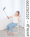 自撮り棒で自撮りする若い女性 102262300
