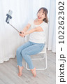 自撮り棒で自撮りする若い女性 102262302