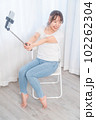 自撮り棒で自撮りする若い女性 102262304