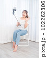 自撮り棒で自撮りする若い女性 102262306