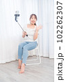 自撮り棒で自撮りする若い女性 102262307