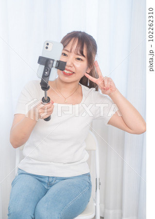 自撮り棒で自撮りする若い女性 102262310