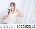 自撮り棒で自撮りする若い女性 102262312