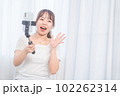 自撮り棒で自撮りする若い女性 102262314