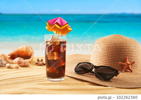Straw hat, sunglasses and cocktail on the sand and sea background. Relax on the beach Straw hat, sunglasses and cocktail on the sand and sea background. Relax on the beach 102262360