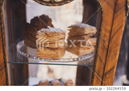 Puff pastry bun rolls sprinkled with sugar powder served in the cafe or bakery window. Homemade bakery product 102264559
