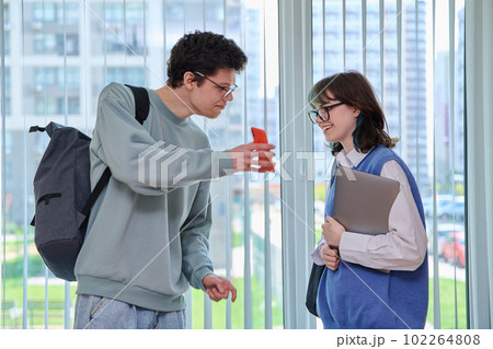Talking laughing college students, guy and girl with backpacks Talking laughing college students, guy and girl with backpacks 102264808