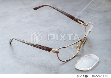 Damaged eyeglasses on table in optical shop waiting for repairing 102265140