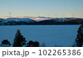 Lot of wind turbines on a snow-capped mountain in the evening at sunset 102265386