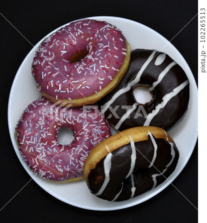 Delicious sweet donuts on a plate. Glazed doughnuts. 102265513