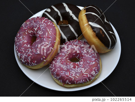 Delicious sweet donuts on a plate. Glazed doughnuts. 102265514