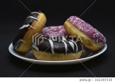 Delicious sweet donuts on a plate. Glazed doughnuts. 102265516