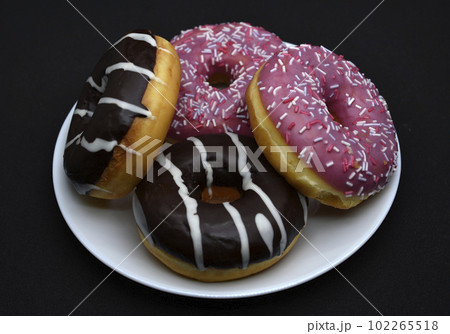 Delicious sweet donuts on a plate. Glazed doughnuts. 102265518