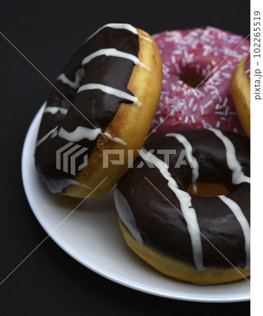 Delicious sweet donuts on a plate. Glazed doughnuts. 102265519