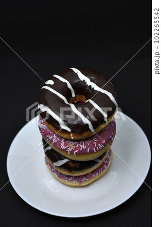Delicious sweet donuts on a plate. Glazed doughnuts. 102265542