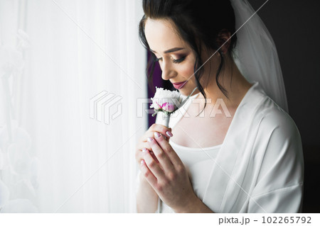 Beautiful bride wearing fashion wedding dress with feathers with luxury delight make-up and hairstyle, studio indoor photo shoot Beautiful bride wearing fashion wedding dress with feathers with luxury delight make-up and hairstyle, studio indoor photo shoot 102265792