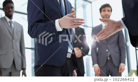handshake of business partners against the background of colleag 102266412