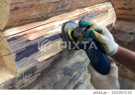 Grinding by polishing machine of pine logs at home. Cleaning wood from fungus and mold. 102267210