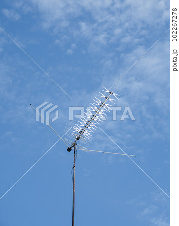 TV rooftop antenna on blue sky background. Industrial equipment used to receive internet signal, television connection and communication. TV rooftop antenna on blue sky background. Industrial equipment used to receive internet signal, television connection and communication. 102267278