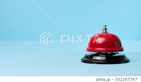 Metallic red bell to call staff on a blue background 102267767