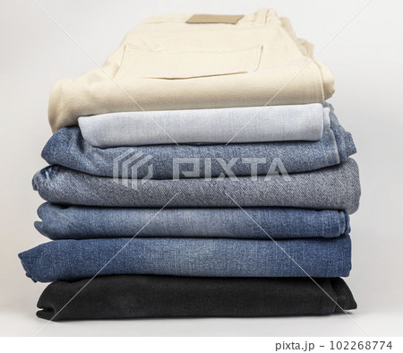 A pile of different jeans, on a white background. The concept of updating the wardrobe. A pile of different jeans, on a white background. The concept of updating the wardrobe. 102268774