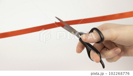 Opening of a new project. Cutting the red ribbon with scissors. Close up. Opening of a new project. Cutting the red ribbon with scissors. Close up. 102268776