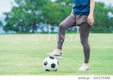 サッカー場でユニフォームを着てサッカー・フットサルの練習をする日本人女性 102270366