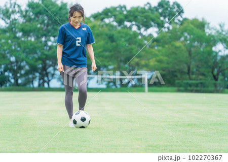 サッカー場でユニフォームを着てサッカー・フットサルの練習をする日本人女性 102270367
