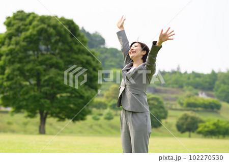 バンザイをするビジネススーツの若い女性 102270530