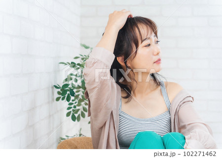 椅子に座ってリラックスするおしゃれなアジア人女性 102271462
