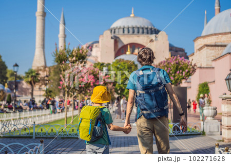 Father and son Tourists enjoy beautiful view on Hagia Sophia Cathedral, famous islamic Landmark mosque, Travel to Istanbul, Turkey. Traveling with kids concept. Sunny day architecture and Hagia Sophia 102271628