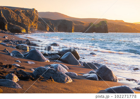 Beach with Black Sand by Low Tide at Sunset. Volcanic Coastline with Beautiful Light in Iceland. 102271778