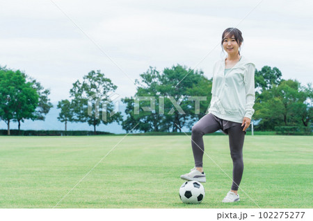 サッカー場でサッカー・フットサルの練習をする日本人女性 サッカー場でサッカー・フットサルの練習をする日本人女性 102275277