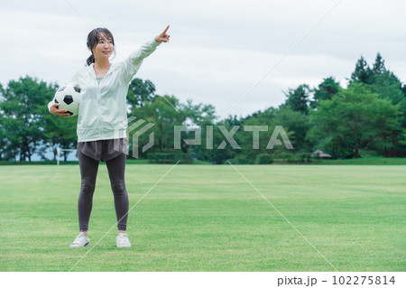 目標を指差すサッカーするファン・サポーターの日本人女性 102275814