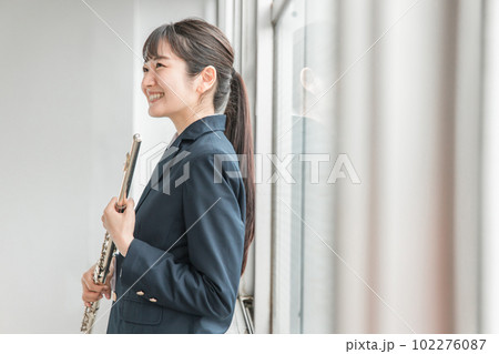 学校の教室でフルートを吹く吹奏楽部のアジア人女子高生 学校の教室でフルートを吹く吹奏楽部のアジア人女子高生 102276087
