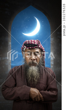 Muslim man with a beard wearing keffiyeh with agal in praying position (salat) on the prayer rug 102276328