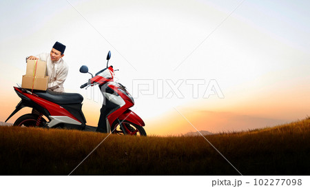 Asian Muslim man tying box on motorcycle prepare for mudik 102277098